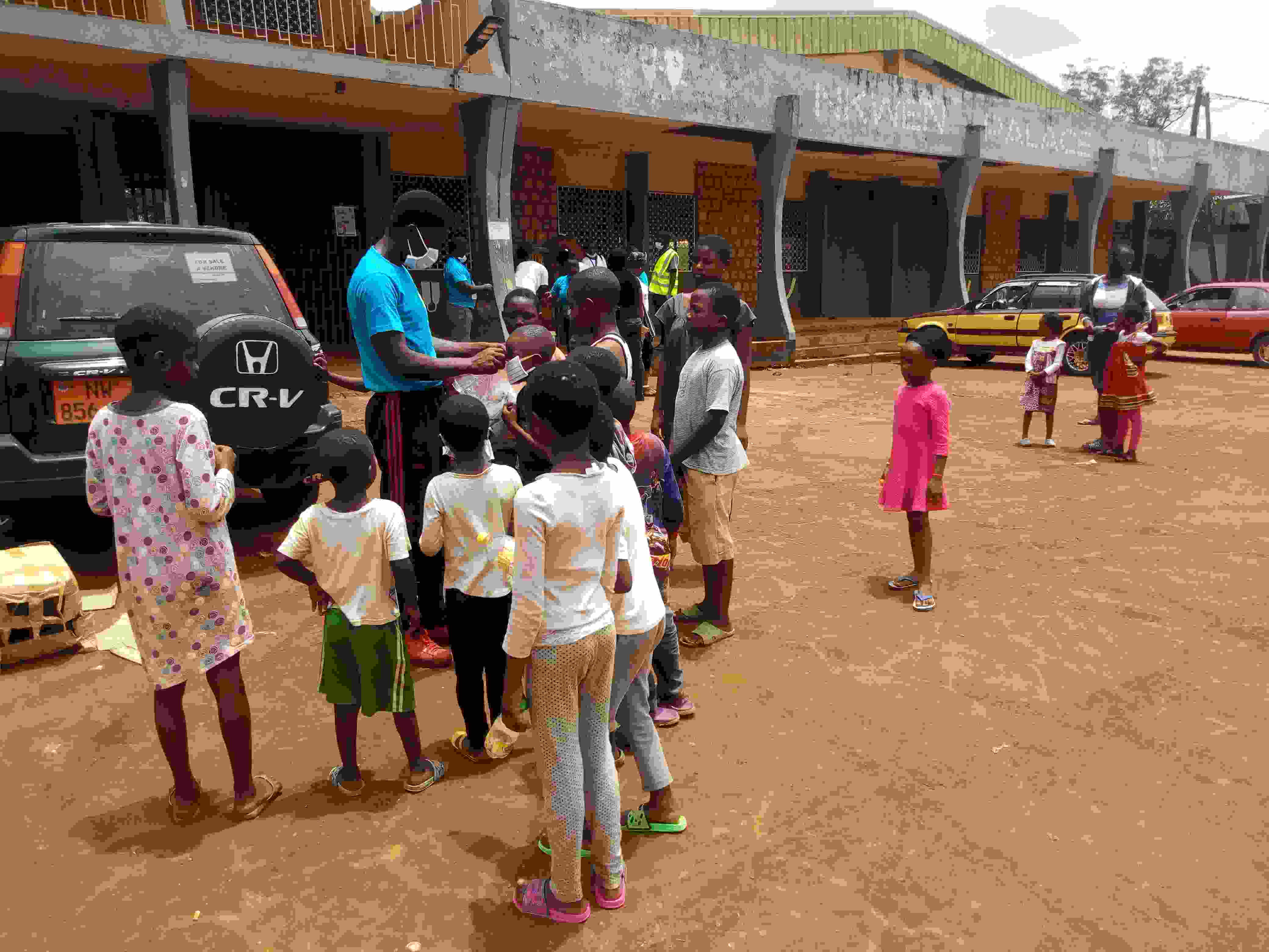 Muma Azehfor teaching children how to put on mask